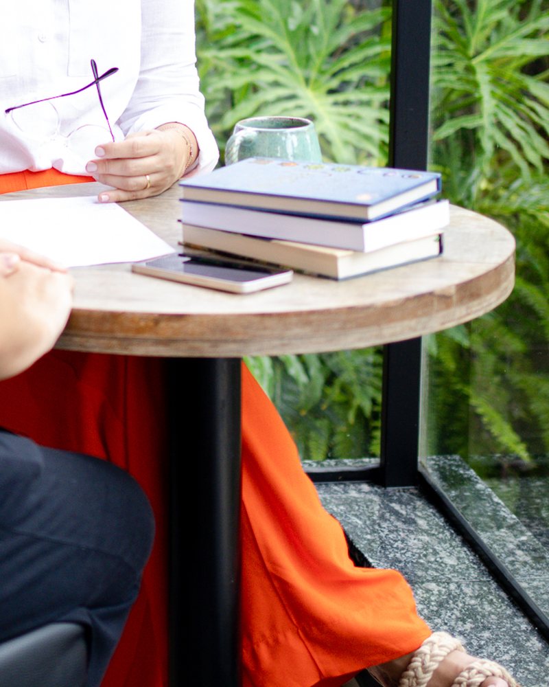 Livros, caderno e óculos sobre a mesa durante uma sessão